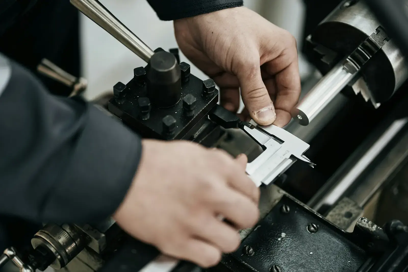 Técnico midiendo una pieza con calibre sobre maquinaria industrial